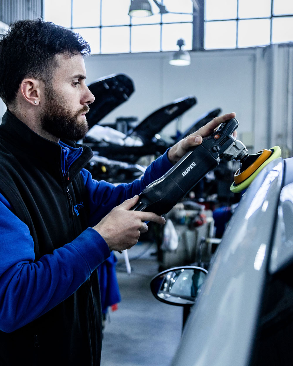 operaio lucida carrozzeria in officina