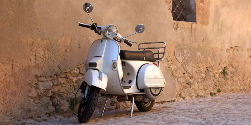 vespa grigia contro muro